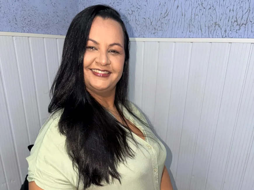 Helen Ferreira, psicóloga, sentada com uma caneca, sorrindo para a câmera